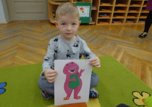 Chłopiec pokazuje postać Barney